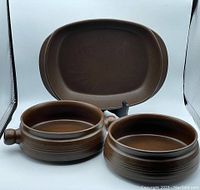 Set of three Langley/Denby 'Mayflower' brown ceramic serving pieces, showing platter and two round dishes.