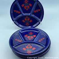 Set of 4 round cobalt blue ceramic fondue plates with divided sections and Bavarian-style floral heart motif.