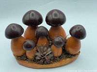 Full view of the vintage wood mushroom decor showing all seven mushrooms, pinecone, and moss on the wooden base.