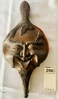 Front view of carved smiling face on bellows