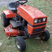 Front-side view showing hood, headlights, front wheels and mowing deck.
