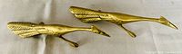 Top view of pair of solid brass peacock figurines showing body and tail feather details