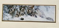 Close-up of the wolf artwork showing detailed winter scene of two gray wolves lying in snow beneath pine branches.