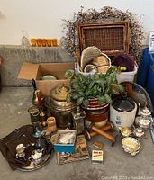 Overview of all items including baskets, crock jug, yarn spools, brass items, and amber glass cups.