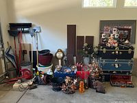 Wide view of trunks, yard tools, household decor, and miscellaneous items in garage space.