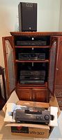 six Kenwood components stacked in open cabinet with Yamaha speaker on top