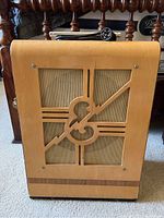 Front view of wooden cabinet displaying Epiphone monogram cut-out and cloth speaker grille
