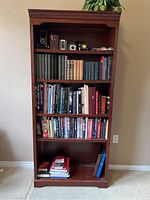 Front view of wood bookcase showing books and decorative items on shelves