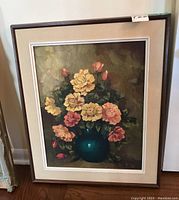 Overall view of framed oil painting depicting bouquet of yellow and pink roses in blue vase.