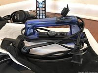 Travel iron with blue plastic housing, power cord, and black dial control with temperature settings.