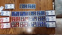 Overhead view of all white slipcases and plastic carded coin sets arranged on a wood table