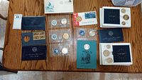 Overview photo showing all coins, envelopes, and presentation cases arranged on table.