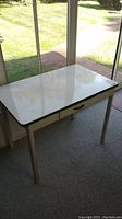Front view of the enamelware table with white glossy top and four legs