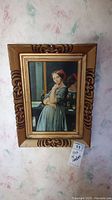 Front view of first framed painting showing woman in blue dress with mirror reflection behind her, ornate gold frame.