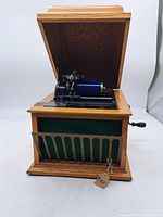 Overall front view of the Edison Amberola phonograph with lid open showing cylinder and hand crank