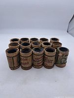 Front view of 15 vintage Edison moulded music cylinders in original cardboard tubes with worn paper labels.