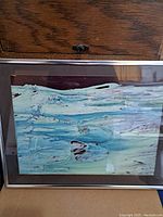Full view of framed artwork showing abstract oceanic theme with blues, greens, and maroon colors.