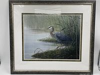 Framed print showing the heron in wetland setting with detailed grass and water reflections.