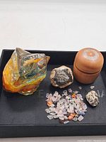 Photo showing entire lot including large decorative glass, two mineral specimens, wooden container, and small tumbled stones.