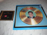 Photo showing Elvis Presley 3 Volume Golden Records vinyl album cover and the 'I Miss Elvis Presley' CD case.