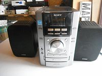 Front view of Sony mini stereo unit with Koss speakers on each side on a white surface.