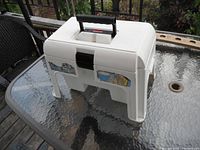 White Rubbermaid plastic step stool closed showing exterior including handle and side stickers