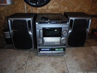 Full front view of the AIWA stereo system with speakers placed on either side, showing unit design and controls