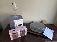 Set of four clear stemmed wine glasses with a box, two 'Mine' and 'Yours' wine tumblers in pink box, and three-tier slate serving dish stacked and wrapped.