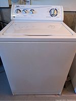 Front view of Inglis white top load washing machine with control panel and lid closed.