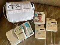 Photo showing the ME hair removal device with carrying case and three cartridge boxes including facial hair removal kit and TANDA cartridges.