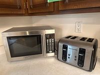 Sylvania microwave and KitchenAid toaster placed side-by-side on a kitchen countertop.