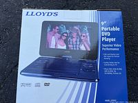 Box showing front image of the Lloyd's 9-inch portable DVD player with the screen displaying a group photo and buttons visible on the base unit.