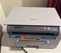 Front view of Samsung SCX-4200 laser multifunction printer with control panel and front paper tray visible.