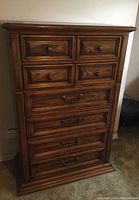 Front view of Sklar Peppler tall boy dresser showing six drawers with metal handles and wood grain finish, good detail on molding and drawer design.
