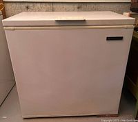 Front view of the white chest freezer showing the rectangular shape and flat top with handle.