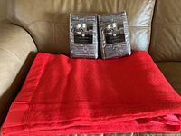 Red Kenwood wool blanket spread out with two new packaged grey Hotel Collection pillow shams placed on top