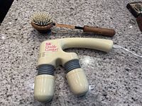 Image showing both the Japanese back scratcher and Wahl Double Comfort massager on a granite countertop.