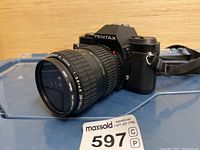 Front angle of black Pentax P3n SLR camera showing attached Takumar-A Zoom 35-80mm f/3.5-4.5 lens in zoomed out position.