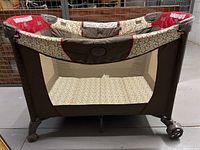 Front view of Safety 1st collapsible play pen showing mesh sides and patterned bottom.