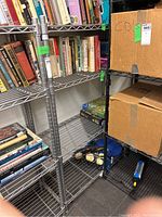 Photo of the shelving unit partially filled with books and boxes, showing metal wire shelves and frame.