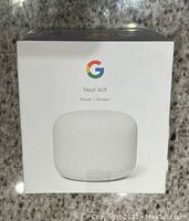 Front of box showing Google Nest Wifi router image, logo, and product name.