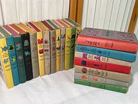 Books arranged upright, showing variety of colourful spines, titles, and illustrations representing Junior Deluxe Editions children's books.