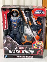 Box front showing Taskmaster figure and included Blast Gear accessories in packaging.