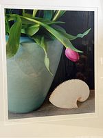 Full view of framed print showing green vase, pink tulip, and white seashell on wood surface