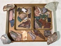Full view of the box containing about 20+ rock and mineral specimens.