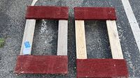 Pair of wooden rolling dollies from top view showing red carpet sections on ends and weathered wood surfaces