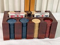 Front view showing all 8 slots of color-coded poker chips and two decks of cards in wooden holder
