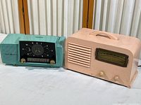 Both radios displayed side by side on a white surface, showing size and color comparison.