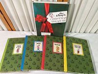 Photo showing the five books on a white surface. Four green hardcover books from the Wonderful World of Walt Disney series with colored spines and a Christmas Treasury book with dust jacket standing behind.