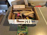 Wooden train tracks, train cars, and accessories in wooden box